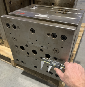 Measure the diameter of the thru-hole in the ejector plate housing of the mold.